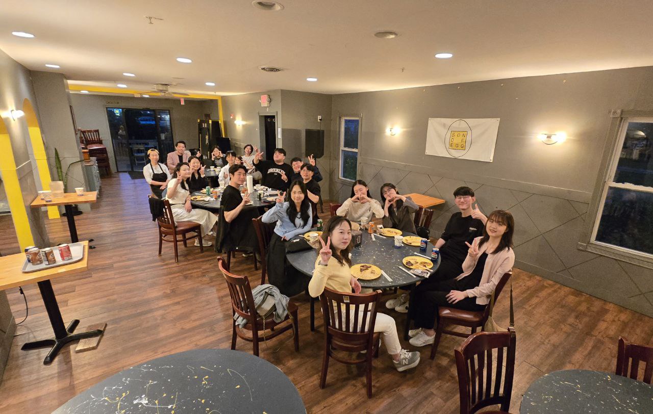 Group celebrating at round tables in the Son of Egg event space